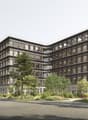 modern office building, multiple floors, large windows, balconies, surrounded by trees and greenery