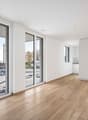 sliding glass doors, large windows, wooden floor, kitchen on the side, empty room