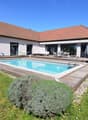 Modern house with swimming pool, wooden deck, and garden