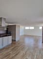 modern kitchen with wooden floor, white walls, built-in appliances, large windows