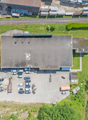 Large building with an attached parking lot and vehicles parked in it.