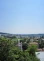 Cityscape with multiple buildings, trees, and a clear blue sky