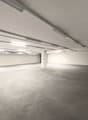 empty room, white walls, gray floor, fluorescent lights on ceiling