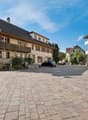 3 story house, brick facade, wooden balcony, brick driveway