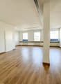 empty room, wooden floor, white walls, three windows, central pillar, white door