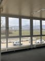 Wide windows, empty room, view of vehicles in parking area