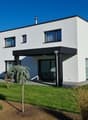 Modern 2 story house, white exterior, solar panels, covered terrace, spacious front yard