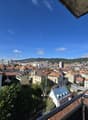 panoramic city view, buildings, hills, greenery, balconies