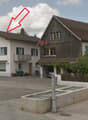 Two story house, white paint, wooden house at back, garage