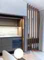 kitchenette with marble countertops, under cabinet lighting, pull out microwave and oven, sink with faucet, wooden cabinets, large window