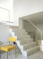 White marble stairs, yellow chair, stone countertop, marble flooring, modern design