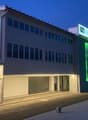 Hotel with multiple floors, modern architecture, garage, and illuminated signage