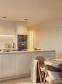 modern kitchen with white cabinets, marble countertop, island, built-in oven, stove, sink, faucet, dining area with wooden table, chairs, rug, plants, TV
