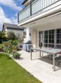 patio with table and chairs, plants, grass, balcony