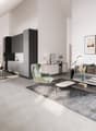 Open plan living, dining, and kitchen area with modern furnishings, large windows, vaulted ceilings, and artwork.