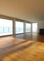 large windows, wooden floor, empty room, balcony, sea view