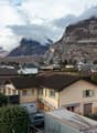 Detached house, brown roof, large yard, garage, located in a hilly, rural area, mountains in the background