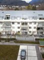 modern apartment building, balcony on every floor, multiple parking spots, green roof