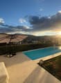Outdoor area with swimming pool, umbrella, plants, and a view of the city