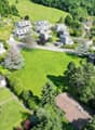 an aerial view of a building lot surrounded by houses and lush green trees and grass