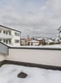white concrete building, covered balcony, covered in snow