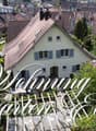 House with garden, multiple houses in the background, trees, plants, and flowers