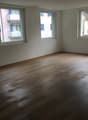 empty room, wooden floor, white walls, three windows, balcony outside