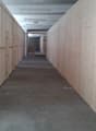 Concrete floor, white and light brown wooden walls, overhead lights