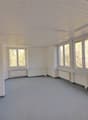 empty room, white walls, gray floor, large windows, white radiators