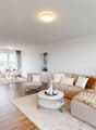 Living room with beige couch, white coffee table, white rug, and beige armchairs