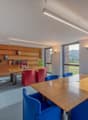 wooden desks and shelves, large windows, modern furniture, carpeting, bright lighting