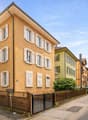 3 story house, yellow exterior, white shutters, wooden fence, street view