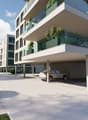 Modern apartment building with glass balconies, underground parking, and a spacious parking area.
