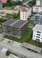 multi-storey apartment buildings, solar panels, swimming pool, several cars parked in underground parking