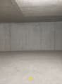 Empty parking area with concrete walls, yellow markings, and a red light