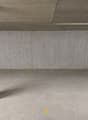 Empty parking lot with concrete walls, yellow markings, and a central column.