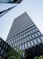 Skyscraper made of black material, many windows, modern design, urban setting