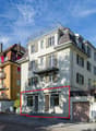 4 story building, cream exterior, red line marks out ground floor apartment for sale