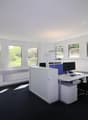 modern office room, white walls, black carpet, large windows, desk, computer, chair
