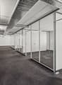 Glass walls and floor, carpeted flooring, silver pipes on ceiling, lights