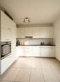 fully equipped kitchen, white cabinets, tiled floor, sink, faucet, coffee maker, dishwasher, oven