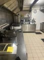 commercial kitchen with oven, microwave, deep fryers, and counter tops, tile flooring