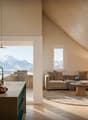 Open kitchen with dining area, living room with couch, coffee table, and rug, large windows with mountain view