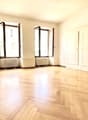 empty room, wooden floors, white walls, three windows, white doors, two white radiators
