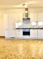 modern kitchen with white cabinets, wooden floor, stainless steel appliances, ceiling lights