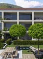 modern building with balconies, landscaped garden, wooden benches, picnic table, loungers