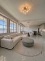 modern living room, white couch, round table, chandelier, marble floor, large windows, dining table, kitchen
