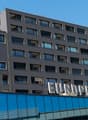 Modern office building with multiple windows, glass facade, signboard reading EUROPLATZ.