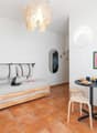 small room with a daybed, a table, and a mirror