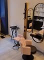 interior of a salon with a window, radiator, mirrors, two armchairs, two stools, and small tables